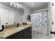 Charming bathroom featuring vanity with granite counters and blue and yellow fish themed shower curtain at 111 Rosignol Dr, Sharpsburg, GA 30277