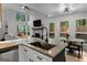 Open-concept kitchen with granite countertops, stainless appliances, and a view of the living room fireplace at 111 Rosignol Dr, Sharpsburg, GA 30277