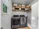Modern laundry room featuring front loading washer and dryer with shelving and decor at 111 Rosignol Dr, Sharpsburg, GA 30277