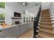 Open living room with large windows, a fireplace, and stairs to upper level at 111 Rosignol Dr, Sharpsburg, GA 30277