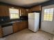 The kitchen features wooden cabinets, a stainless-steel sink, and black appliances at 132 Scarlett Place Dr, Bowdon, GA 30108