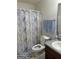Cozy bathroom featuring a shower with marble-patterned curtain, a single sink and wood cabinet at 1432 Eagles Nest Cir, Carrollton, GA 30116