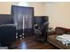 Bedroom featuring a desk and chair, sofa, television, hardwood floors, and curtains at 1432 Eagles Nest Cir, Carrollton, GA 30116