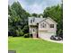 Charming two-story home with a well-manicured lawn and attached garage, nestled among lush trees at 1432 Eagles Nest Cir, Carrollton, GA 30116
