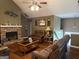 Spacious living room with a stone fireplace, hardwood floors, vaulted ceiling and comfortable leather furniture at 1432 Eagles Nest Cir, Carrollton, GA 30116