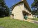 A two-story home with wood siding, shutters, and front stairs, with a lawn covered in yellow flowers on the side at 4079 Day S Trl, Ellenwood, GA 30294
