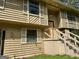 Close-up of a two-story home's exterior, featuring wood siding, shutters, and front stairs needing some repair at 4079 Day S Trl, Ellenwood, GA 30294