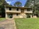 Charming two-story home with a front yard and driveway, surrounded by mature trees on a partly cloudy day at 4079 Day S Trl, Ellenwood, GA 30294