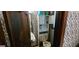 Cozy powder room featuring geometric wallpaper, a vintage toilet, and a wall cabinet at 1992 Kunuga Dr, Jonesboro, GA 30236