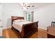 Bedroom with hardwood floors, ceiling fan, and a large, ornate wooden bed frame at 4031 E Meadow Dr, Duluth, GA 30096