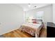 Bright bedroom with hardwood floors, a patterned duvet, and a modern black bed frame at 4031 E Meadow Dr, Duluth, GA 30096