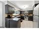 Well-lit kitchen featuring dark cabinets, stainless steel appliances, and tiled backsplash and flooring at 4031 E Meadow Dr, Duluth, GA 30096