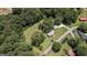 Aerial view showcasing a home with detached garage surrounded by a mix of trees and open space at 204 First St, Bowdon, GA 30108