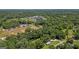 Scenic aerial view of a home, surrounded by dense trees with a glimpse of local neighborhood amenities at 204 First St, Bowdon, GA 30108