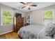 Comfortable bedroom with a ceiling fan, wooden dresser, and ample natural light from the large windows at 204 First St, Bowdon, GA 30108