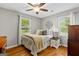 Cozy bedroom featuring hardwood floors, a ceiling fan, and natural light from two windows at 204 First St, Bowdon, GA 30108