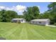 Charming home with a detached garage, surrounded by a large manicured lawn and mature trees at 204 First St, Bowdon, GA 30108