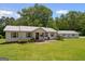 Charming single-story home featuring a metal roof, neutral siding, well-manicured lawn, and detached garage at 204 First St, Bowdon, GA 30108