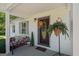 Inviting front porch with decorative door, bench with firewood, and a hanging fern at 204 First St, Bowdon, GA 30108