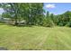 Spacious front yard with mature trees providing shade and privacy for the charming home at 204 First St, Bowdon, GA 30108
