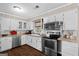 Well-lit kitchen with stainless steel appliances, white cabinets, and a cozy window, perfect for cooking at 204 First St, Bowdon, GA 30108