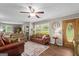 Comfortable living room with wood-look floors, ceiling fan, and abundant natural light at 204 First St, Bowdon, GA 30108