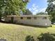 View of the house's backyard featuring a brick wall and a grassy lawn at 3730 Stephanie Sw Dr, Atlanta, GA 30331