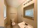 Cozy bathroom featuring a ceramic sink, large mirror, and a comfort height toilet at 3730 Stephanie Sw Dr, Atlanta, GA 30331