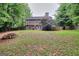 Large backyard with mature trees, a firepit, and a wooden privacy fence at 5765 Woodstone Dr, Cumming, GA 30028