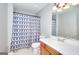 Bathroom with vanity, framed mirror, and a tub-shower with a blue patterned curtain at 5765 Woodstone Dr, Cumming, GA 30028