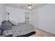 Bedroom features a bed, ceiling fan, window, and closet with bi-fold doors at 5765 Woodstone Dr, Cumming, GA 30028
