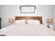 Comfortable bedroom with a bed featuring a wooden headboard, side lamps, and white linens at 5765 Woodstone Dr, Cumming, GA 30028