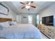 Bedroom features a tray ceiling, queen bed, television, and dresser at 5765 Woodstone Dr, Cumming, GA 30028