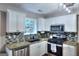 Well-lit kitchen featuring white cabinetry, stainless steel appliances, granite counters and modern backsplash at 5765 Woodstone Dr, Cumming, GA 30028