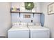 Functional laundry room area with a stacked washer and dryer, decorated with wall art at 5765 Woodstone Dr, Cumming, GA 30028