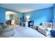 Bright living room with blue walls, comfortable seating, and an open archway to the dining area at 5765 Woodstone Dr, Cumming, GA 30028