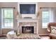 Bright living room with fireplace and mantle decor, with windows providing ample natural light at 5765 Woodstone Dr, Cumming, GA 30028