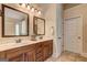 Bathroom featuring double sinks with framed mirrors, and cabinetry with an earth tone color palette at 2360 Braunsroth Ln, Hampton, GA 30228