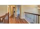 Upstairs hallway with hardwood floors, iron railings, and open doorways at 2360 Braunsroth Ln, Hampton, GA 30228