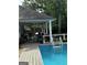 Backyard pool and deck with comfortable seating, a charming covered porch, and shaded swing create a relaxing oasis at 187 Pine Branch Dr, Stockbridge, GA 30281