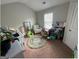 A bedroom with a green and white rug, a crib, and an armchair at 5470 Hilltop Pass, Fairburn, GA 30213
