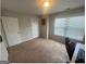 A bedroom with neutral carpet, a window, and two white doors at 5470 Hilltop Pass, Fairburn, GA 30213