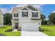 Charming two-story home featuring a two-car garage and well-manicured lawn at 303 Limestone Circle, Conyers, GA 30013