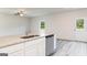 Kitchen island features a stainless steel sink, dishwasher, and gray granite countertops at 303 Limestone Circle, Conyers, GA 30013