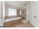 Bright bathroom featuring a soaking tub, a separate glass-enclosed shower, and a neutral color palette at 2100 Willshire Gln, Alpharetta, GA 30009
