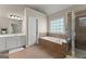 Luxurious bathroom featuring a soaking tub, a separate glass-enclosed shower, and a vanity with dual sinks at 2100 Willshire Gln, Alpharetta, GA 30009