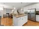 Bright kitchen boasts stainless steel appliances, white cabinets, granite countertops, and an island at 2100 Willshire Gln, Alpharetta, GA 30009