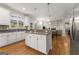 Bright kitchen boasts white cabinets, granite countertops, and an island, flowing into an open floor plan at 2100 Willshire Gln, Alpharetta, GA 30009