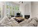 Inviting living room features soaring windows, fireplace, and comfortable sectional seating, and hardwood flooring at 2100 Willshire Gln, Alpharetta, GA 30009