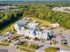 Aerial view of the community clubhouse, pool, tennis courts, parking lots, and beautiful surrounding green space at 123 Mulberry Ct, Peachtree City, GA 30269